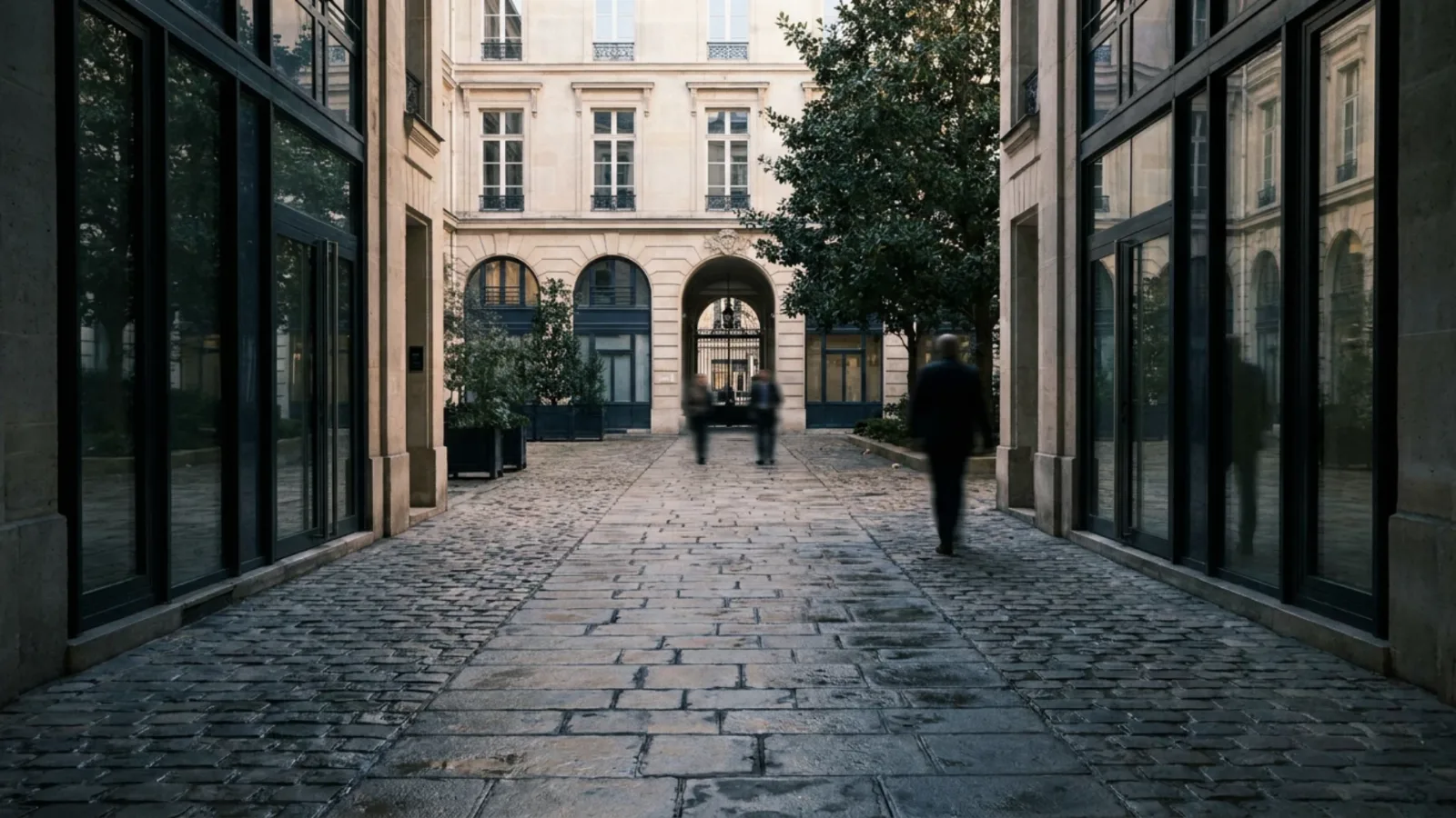 Chemin de dalles de pierre traversant la cour intérieure d’un immeuble de bureaux