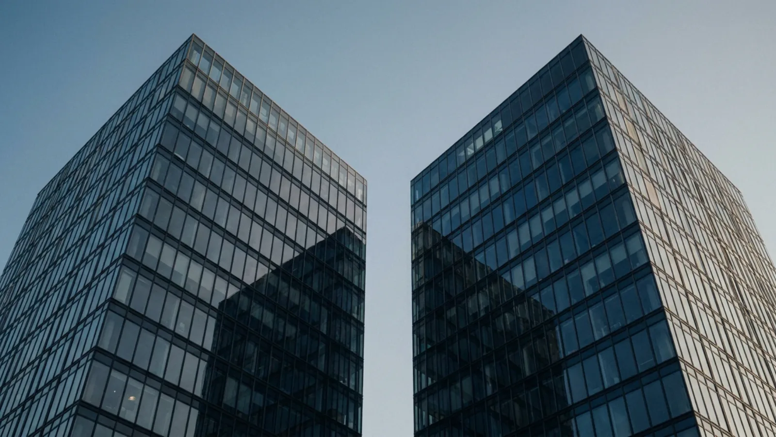 Deux tours de bureaux se faisant face, illustrant la fusion-acquisition