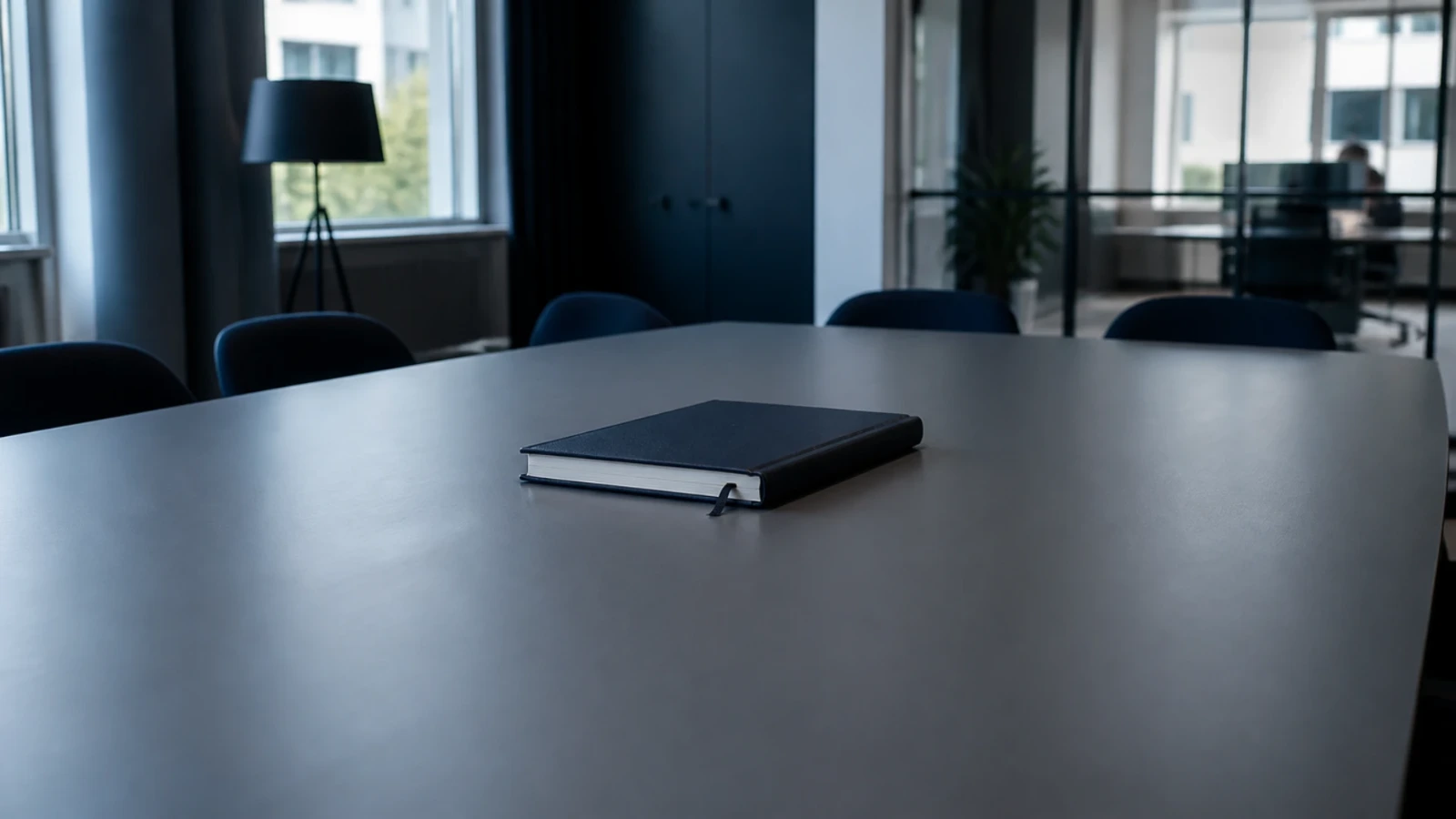 Registre relié fermé posé au centre d’une grande table vide